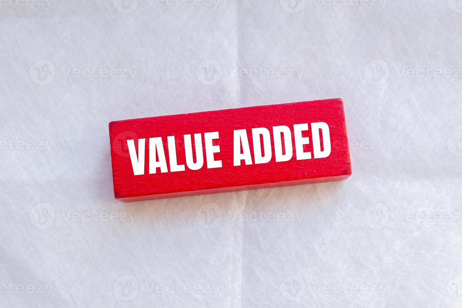 Value added message written on red wooden block with white background. Conceptual value added symbol. Copy space. photo