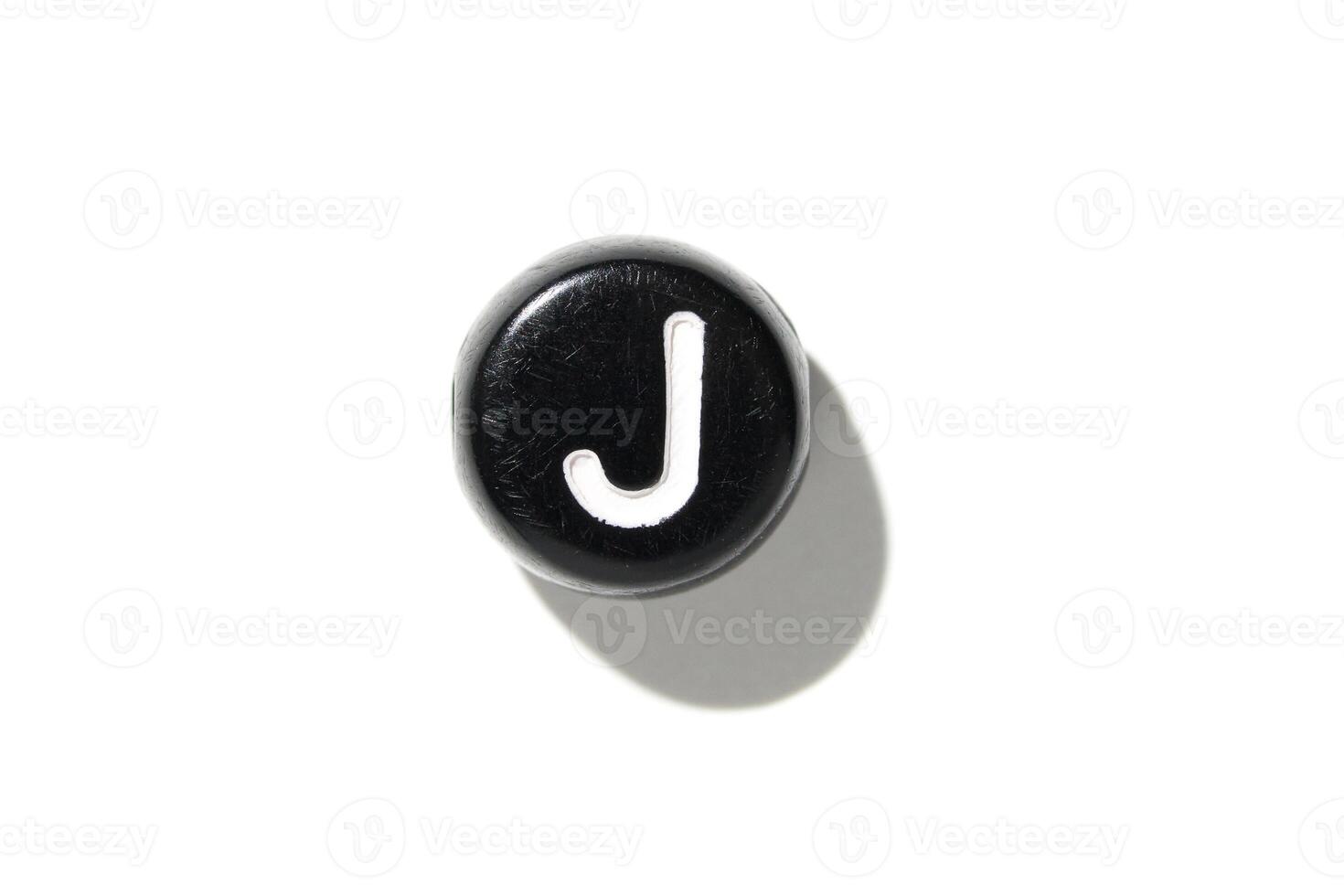 Close-up of black keyboard key with white letter j isolated on white background. photo