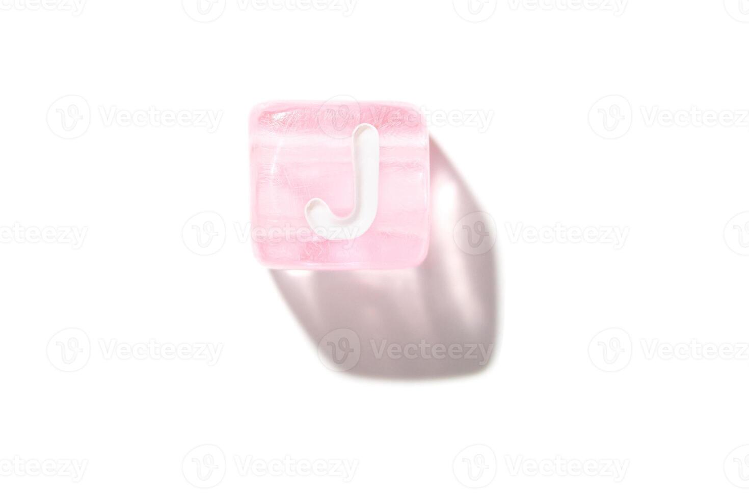 Isolated pink translucent letter j block on white background with soft shadow and minimalist design photo