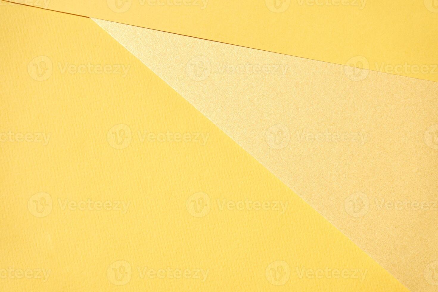 Abstract composition with overlapping yellow textured paper layers creating geometric shapes in minimalistic design. photo