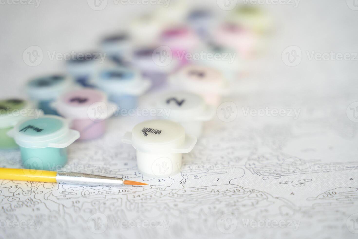 Paint by numbers kit with brush and color pots for relaxing creative art activity on detailed canvas. photo