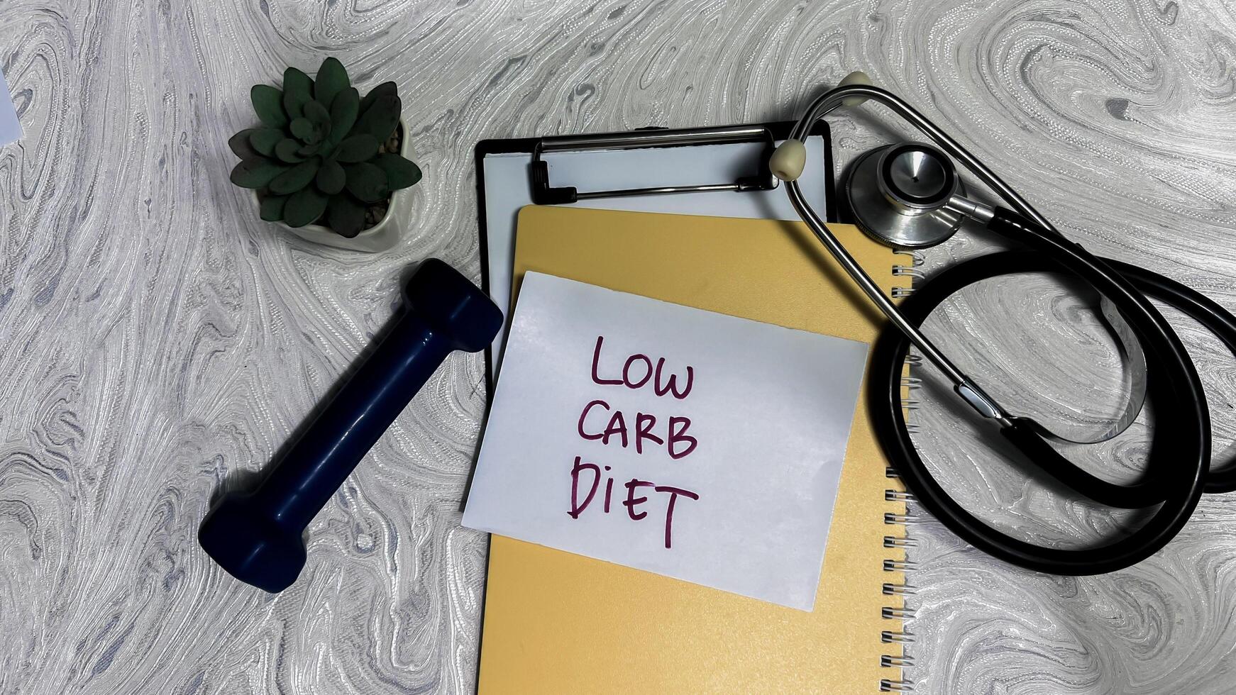Concept of Low Carb Diet write on sticky notes isolated on Wooden Table. photo