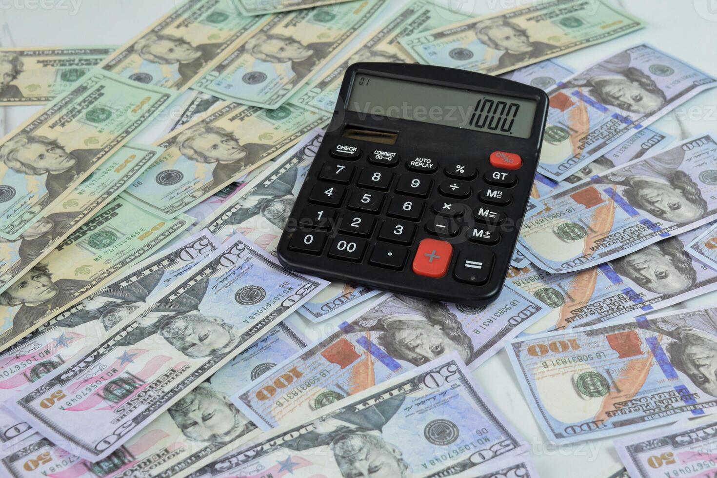 Calculator and a collection of dollar banknotes on the table, financial management concept photo