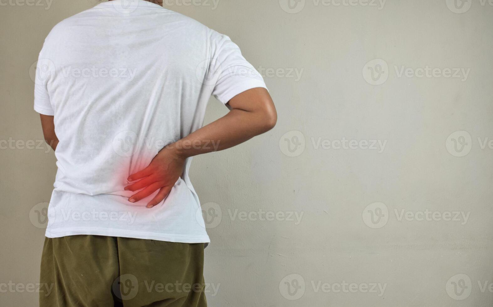 Man standing with hand touching her back having back pain photo