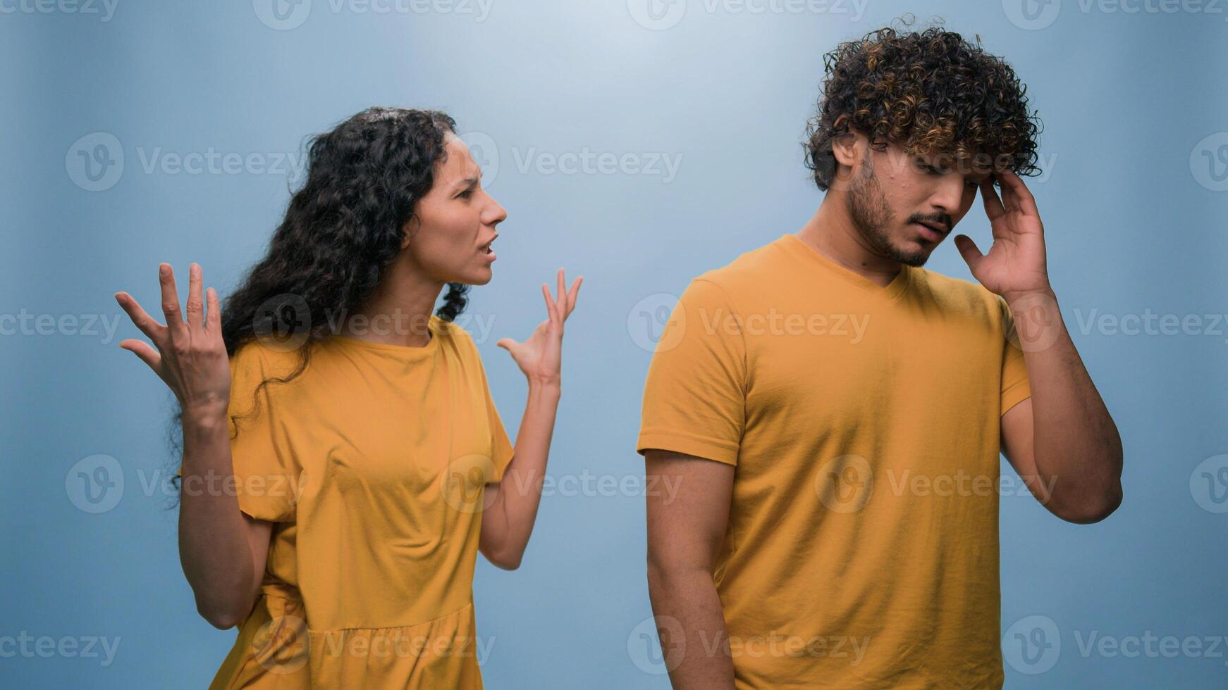 Excited happy shocked wonder amazed surprised Arabian couple winners Indian man woman amazing good news achieve win victory achievement triumph shout screaming yelling winning blue studio background photo