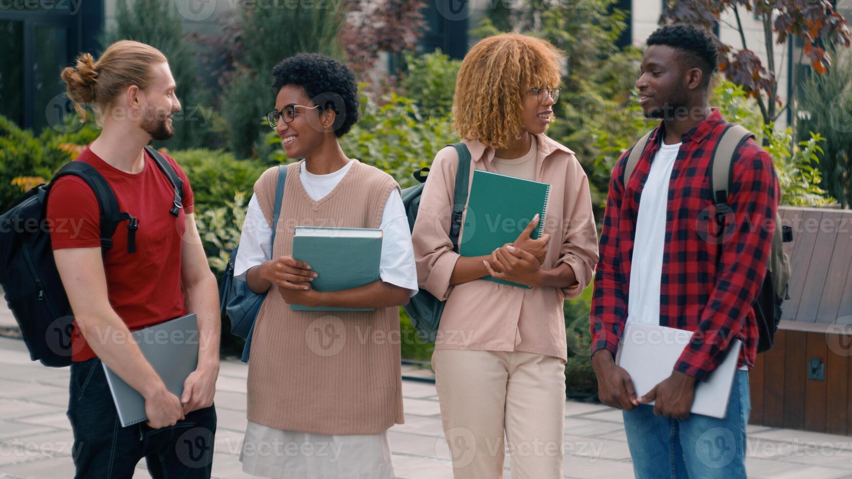 Diverse multiracial gen z friends happy smiling teens students pupils high school university college academy talking together laughing in city cuddling hugging conversation fun friendship education photo