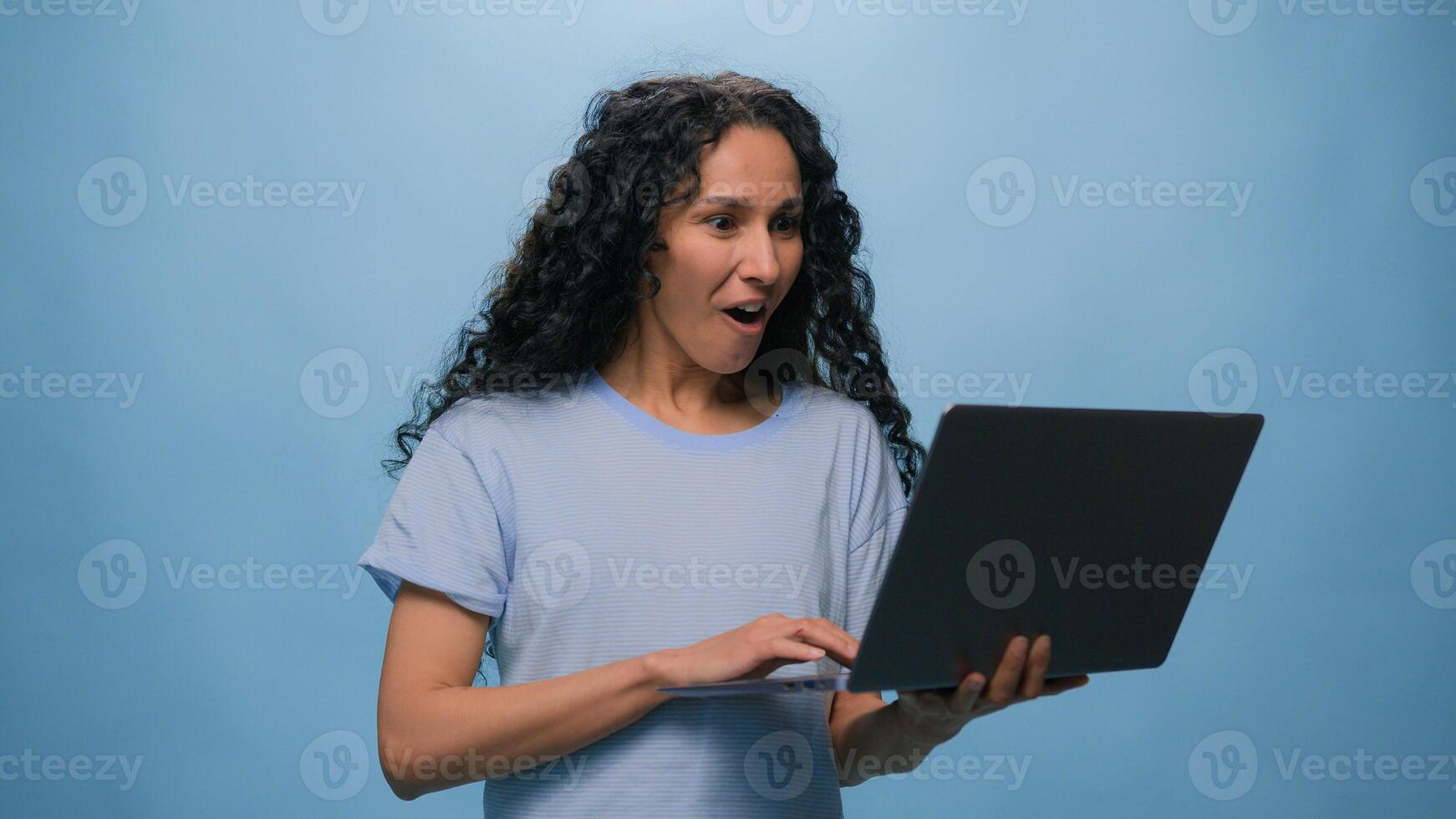 Excited woman female Latino student girl Hispanic user business win laptop online achieve victory computer bet good result champ efficient coding achievement level up bonus at blue studio background photo
