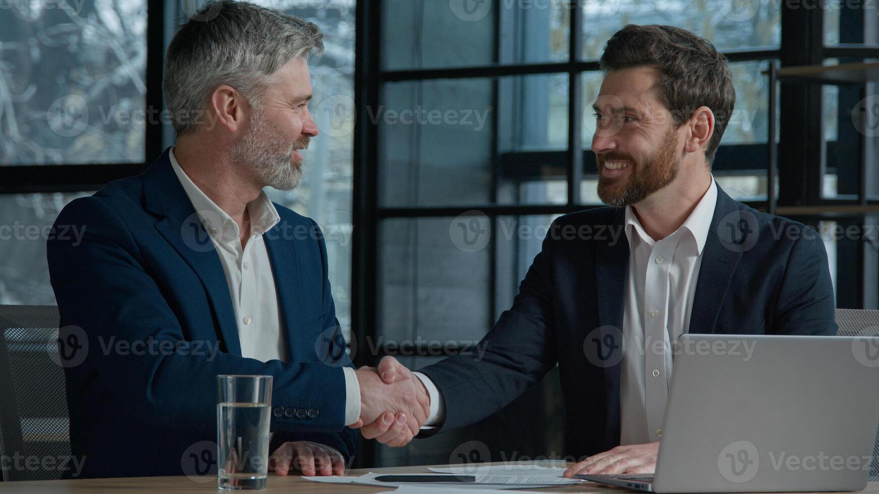 Close-up unrecognizable Caucasian men businessmen business partners employees sign contract document paperwork shaking hands successful partnership deal cooperation agreement handshake in sunny office photo