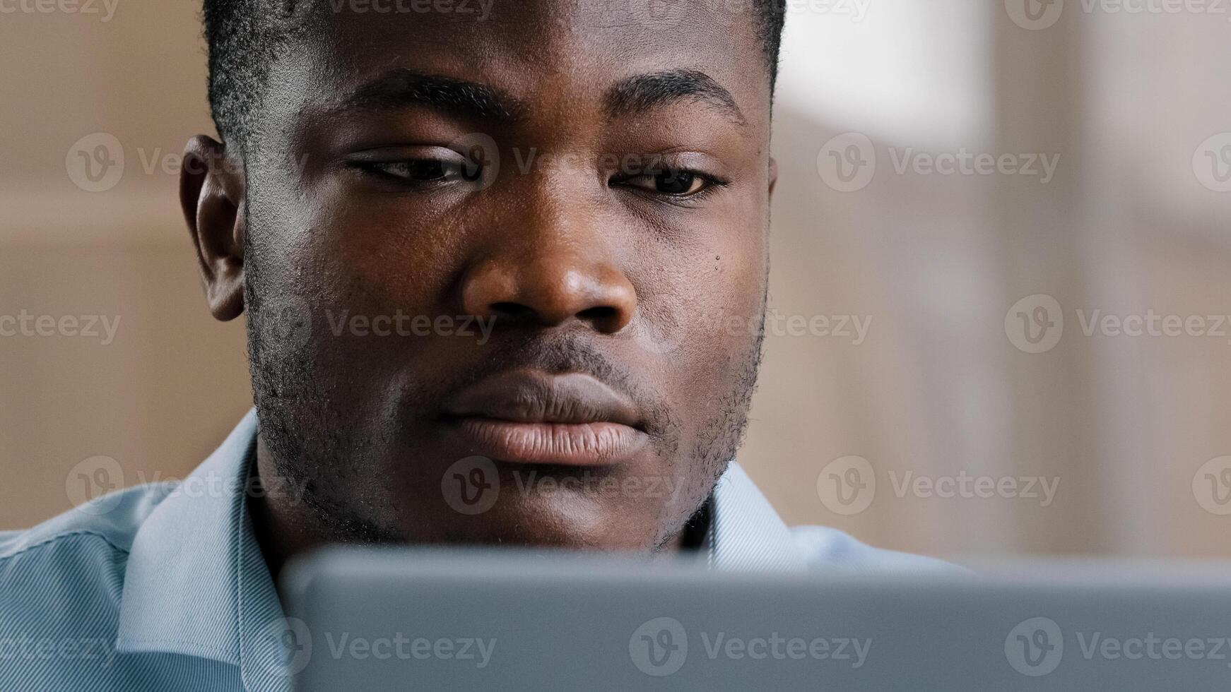 Serious male young african american businessman programmer typing on computer at home office focused concentrated millennial confident guy use laptop create web design for startup research information photo