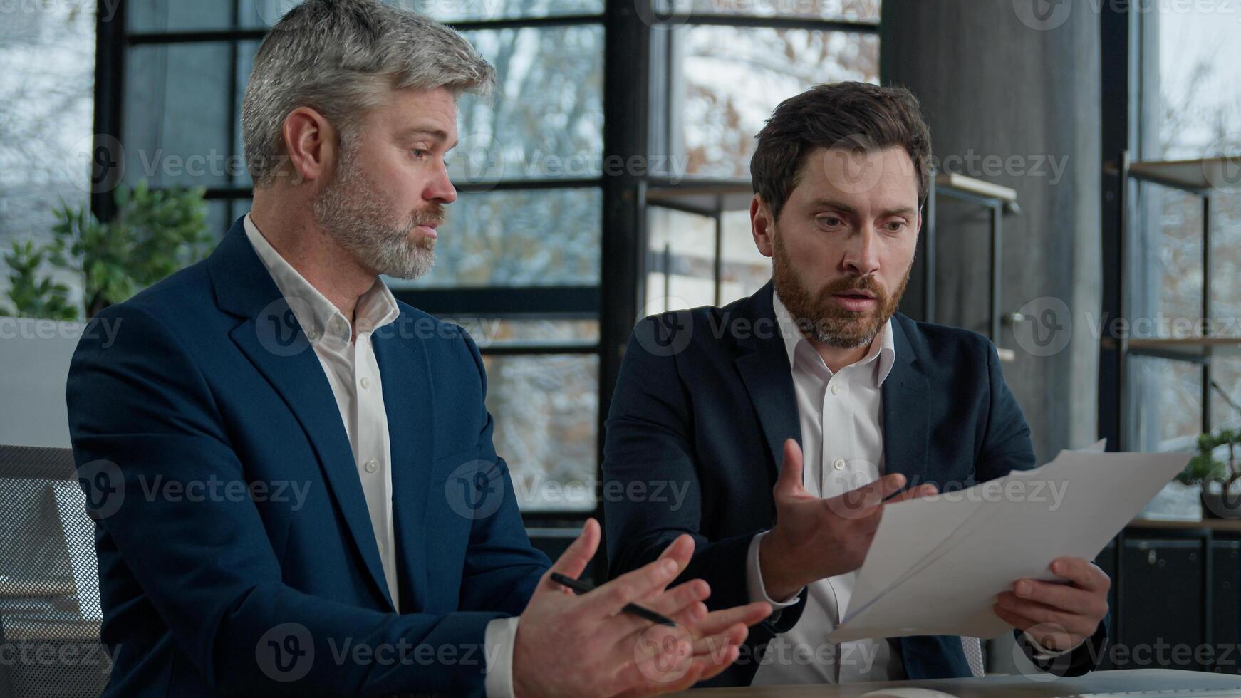 Nervous angry man boss argue scolds employee because mistake in documents financial papers Caucasian men businessmen arguing in office meeting business conflict problem mistake work failure bad result photo