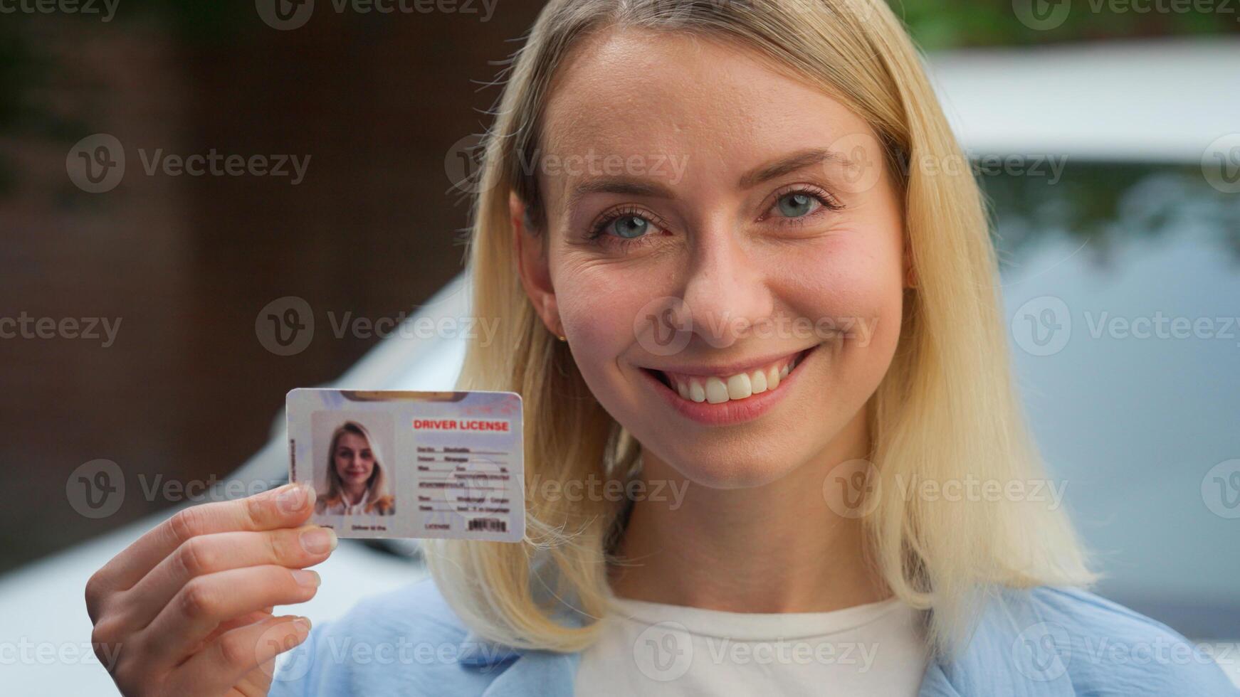 Cheerful Caucasian lady smiling female girl auto transport owner demonstrating driver license in camera in city client happy woman showing document car automobile insurance vehicle rent driving school photo