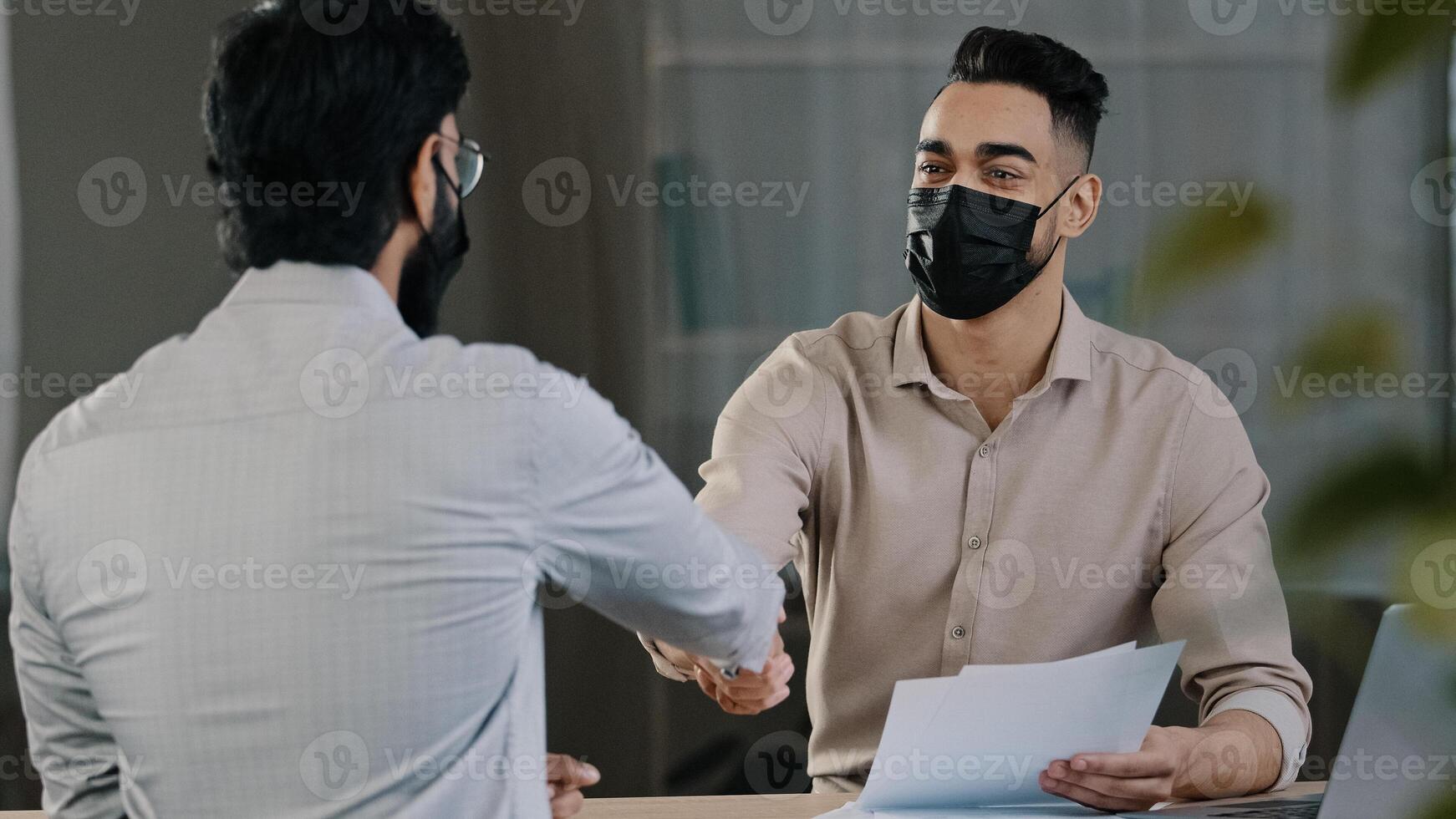 Hispanic businessman man financial salesman analyst ill lawyer in medical mask consult client customer discuss issues project document contract shake hands avoid coronavirus prevent pandemic covid19 photo