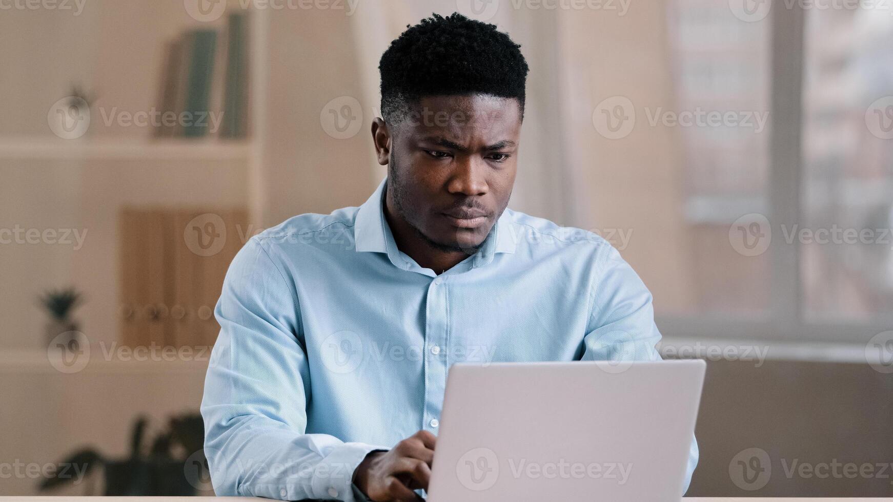 Angry guy annoyed african american man male boss worker dissatisfied has problem with computer system work feels wrath aggression with unsuccessful business deal slow internet read bad news data loss photo