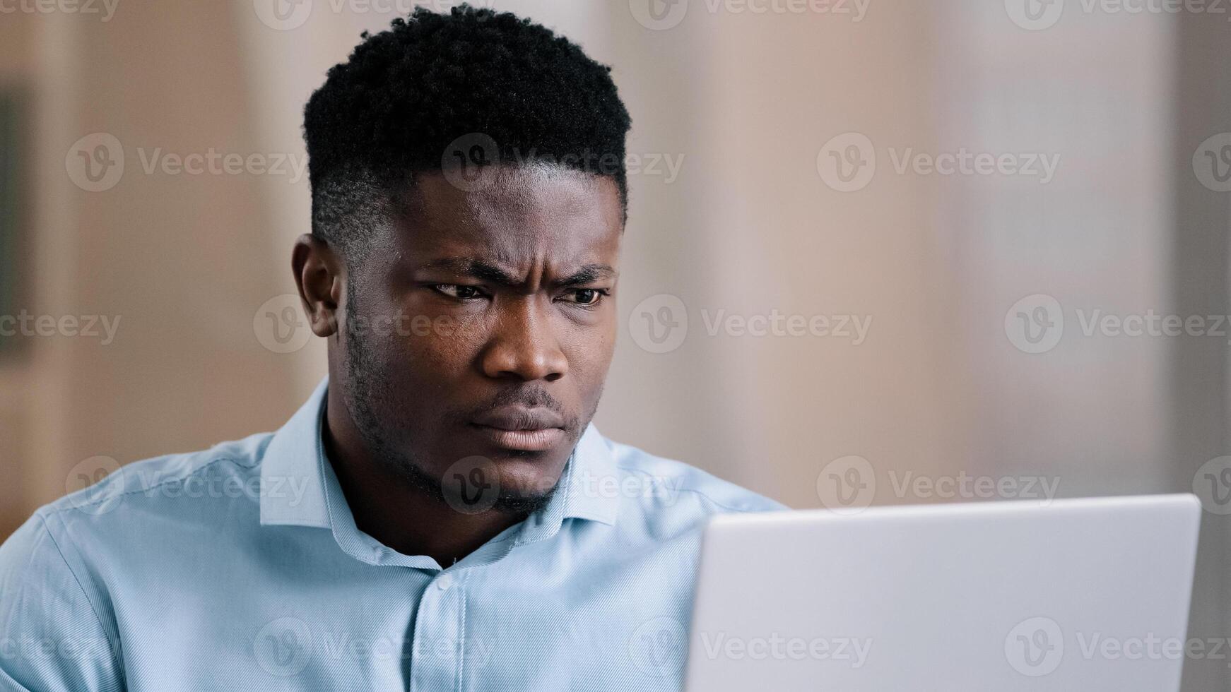 Annoyed african american young man guy businessman boss talk online chat conference feeling furious failure swear quarrel conflict misunderstanding problem point at laptop webcam make no gesture photo