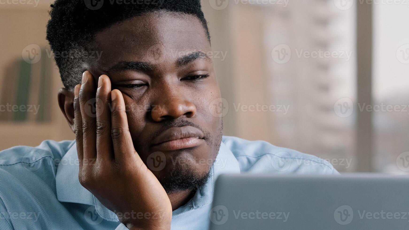 Bored disappointed african man american male businessman have sleeping problem lazy young exhausted guy slumber rest at home workplace feel passive emotion tired from monotone online work at computer photo
