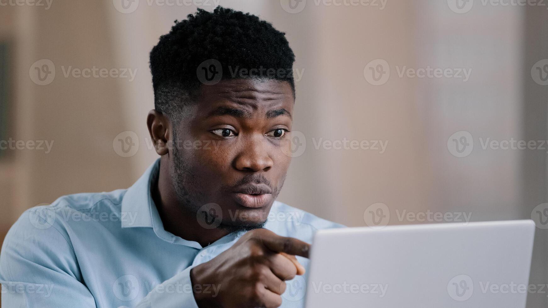 Annoyed african american young man guy businessman boss talk online chat conference feeling furious failure swear quarrel conflict misunderstanding problem point at laptop webcam make no gesture photo