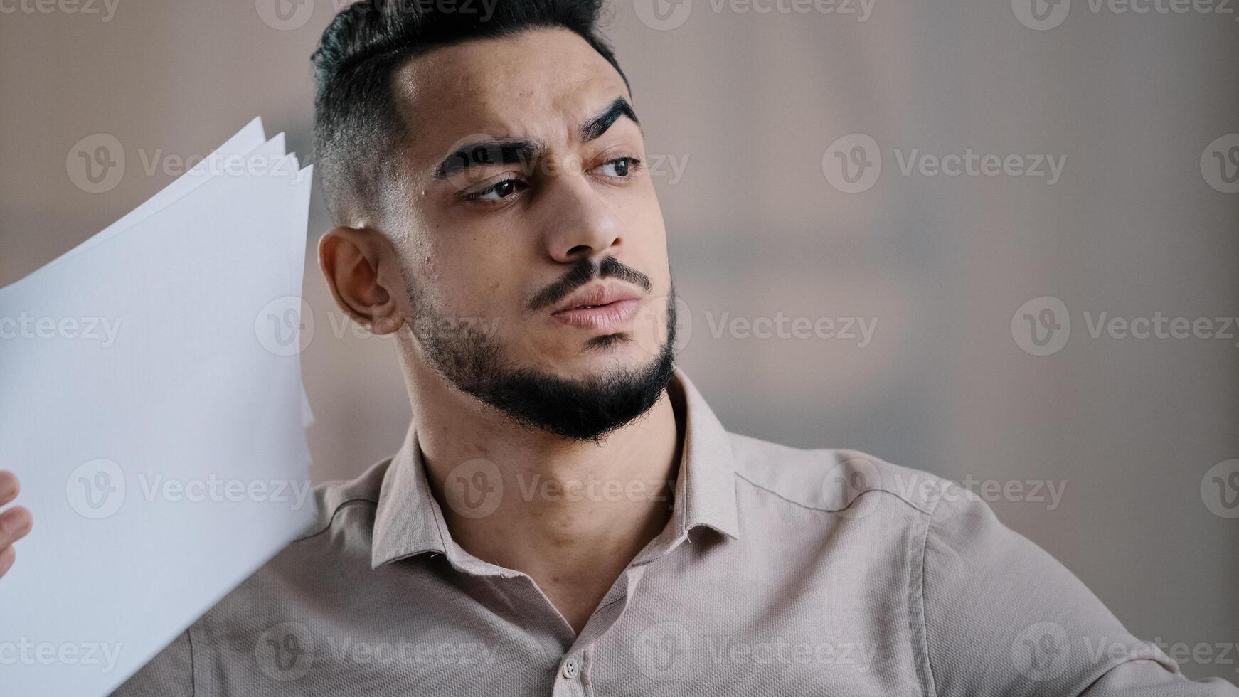 Overheated man hispanic businessman employee suffer from heat high temperature problem at office workplace without air conditioner annoyed male worker feeling hot uncomfortable waving papers cooling photo