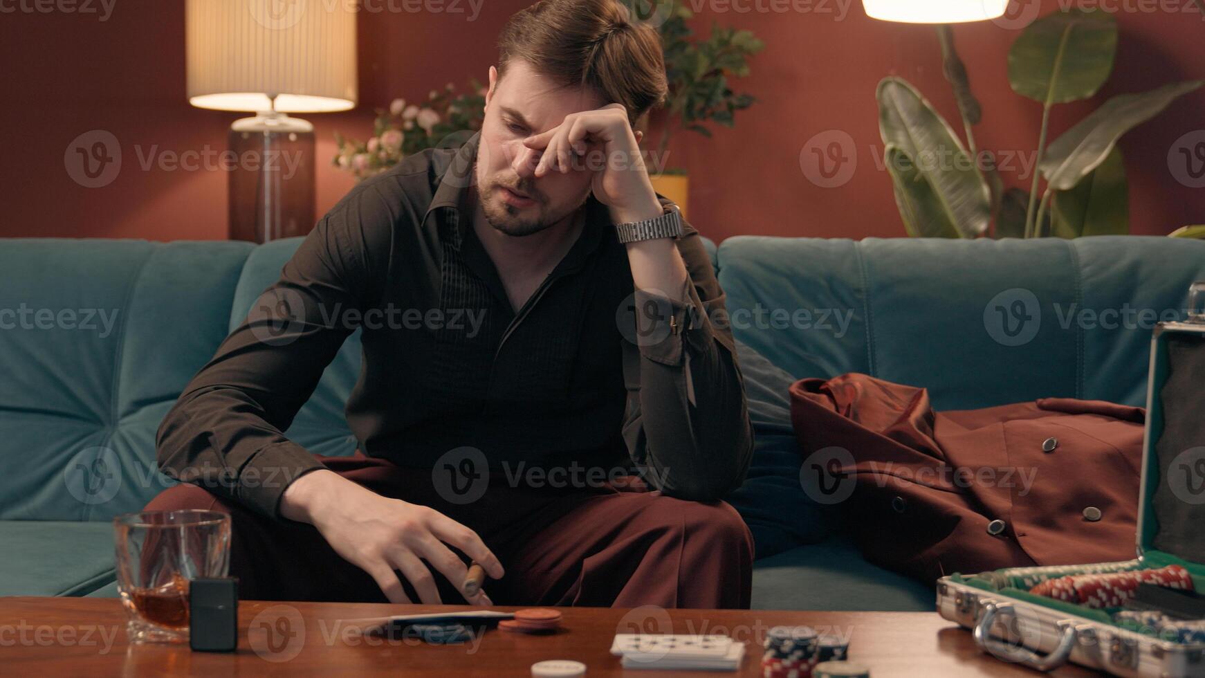 Frustrated sad drunk Caucasian male upset guy man depressed player throwing playing poker cards on table losing game frustration loss bet failure betting defeat addiction inside home evening apartment photo