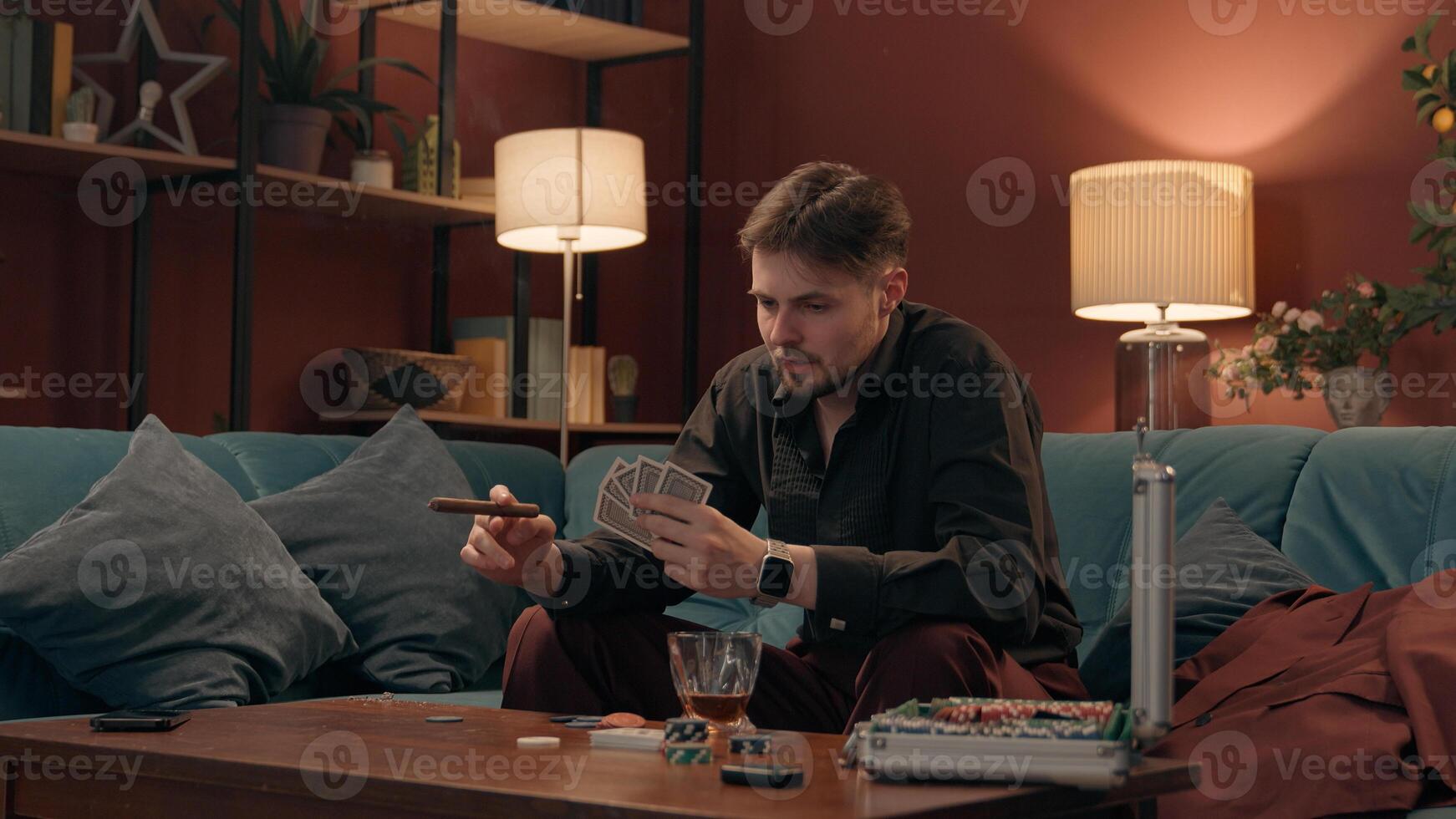 Depressed mad Caucasian angry male gambler gamer man guy smoking cigar looking playing poker cards losing wager lost failure bet throwing card drink whiskey unhealthy habit alcoholism gambling at home photo