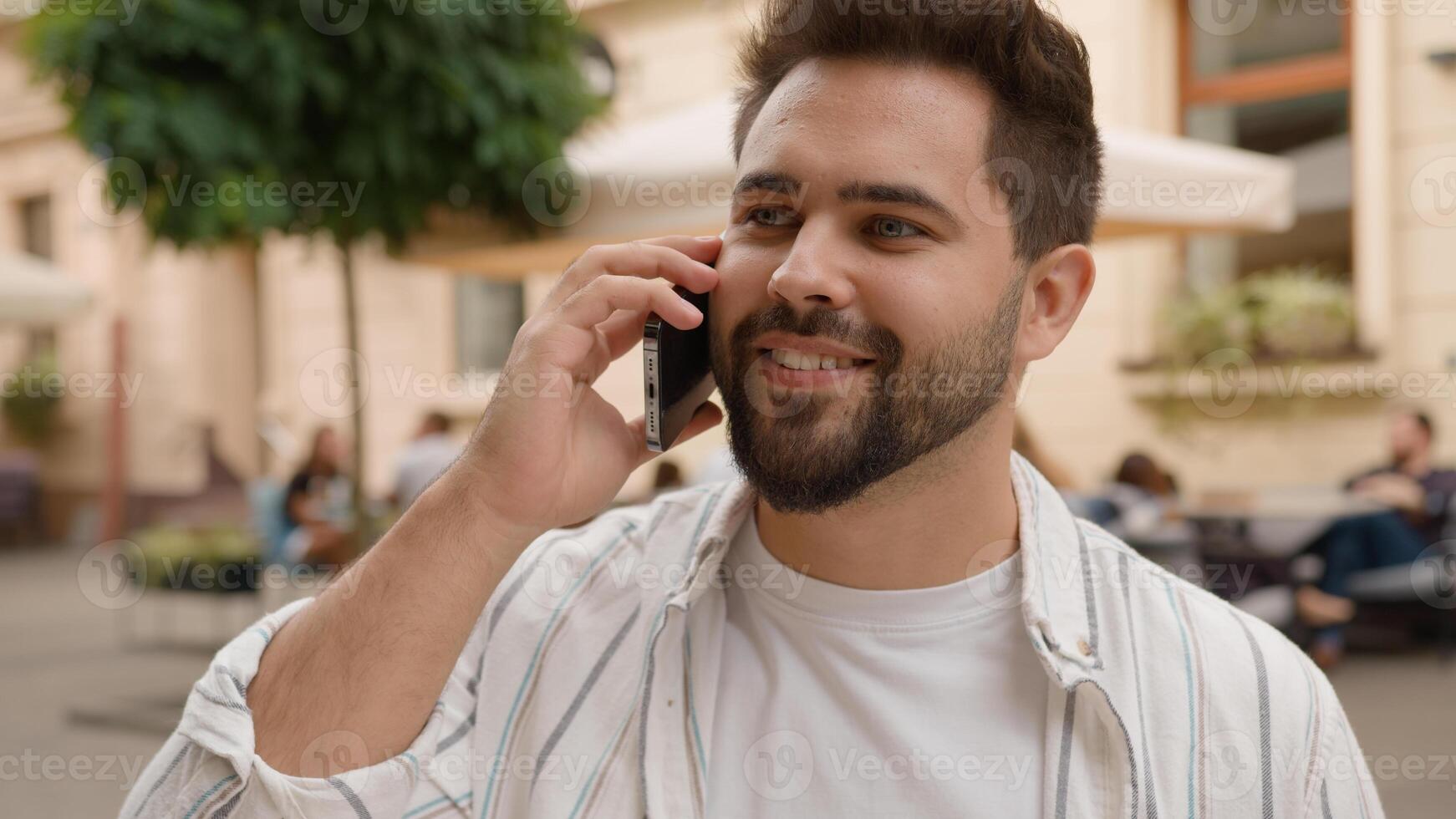 Caucasian male businessman talking cellphone smiling laughing man casual talk mobile phone business call outdoors close up happy guy discuss news friend smartphone communication on city street outside photo