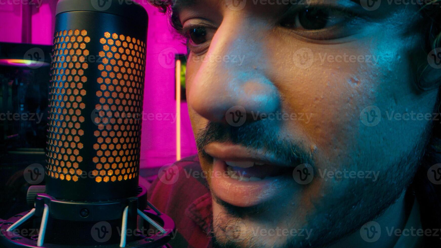 Close up Indian Arabian Muslim man streamer player game cyber sport male microphone mic recording broadcasting guy mouth scream emotions shout computer influence blog radio presenter technology photo
