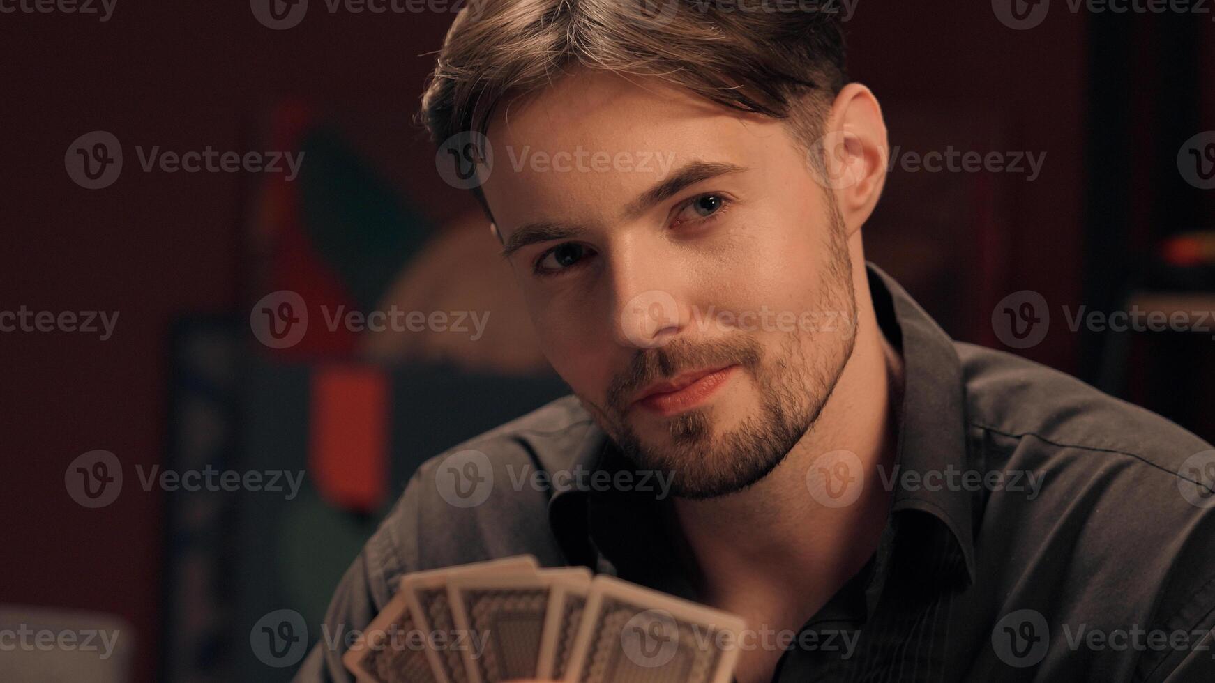Thoughtful cunning focused Caucasian man male guy player gamer holding fan playing poker cards smoking cigar addiction looking at woman female girl rival competitor gaming competition gambling at home photo