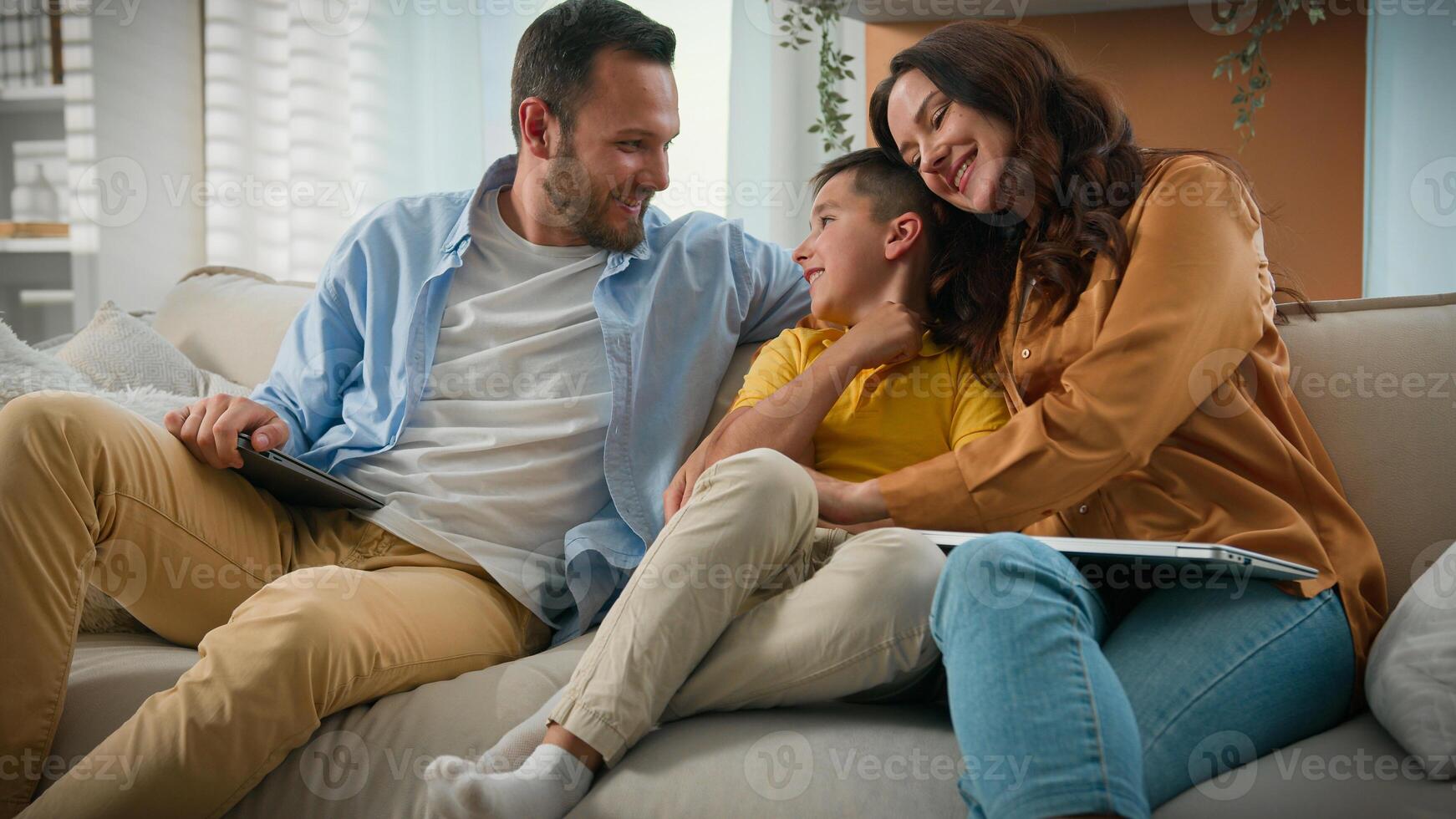 Happy Caucasian family mom dad son parents child kid boy tickling having fun relax on sofa together talking speak cuddle laugh play cuddling loving relationship concept new comfortable home apartment photo