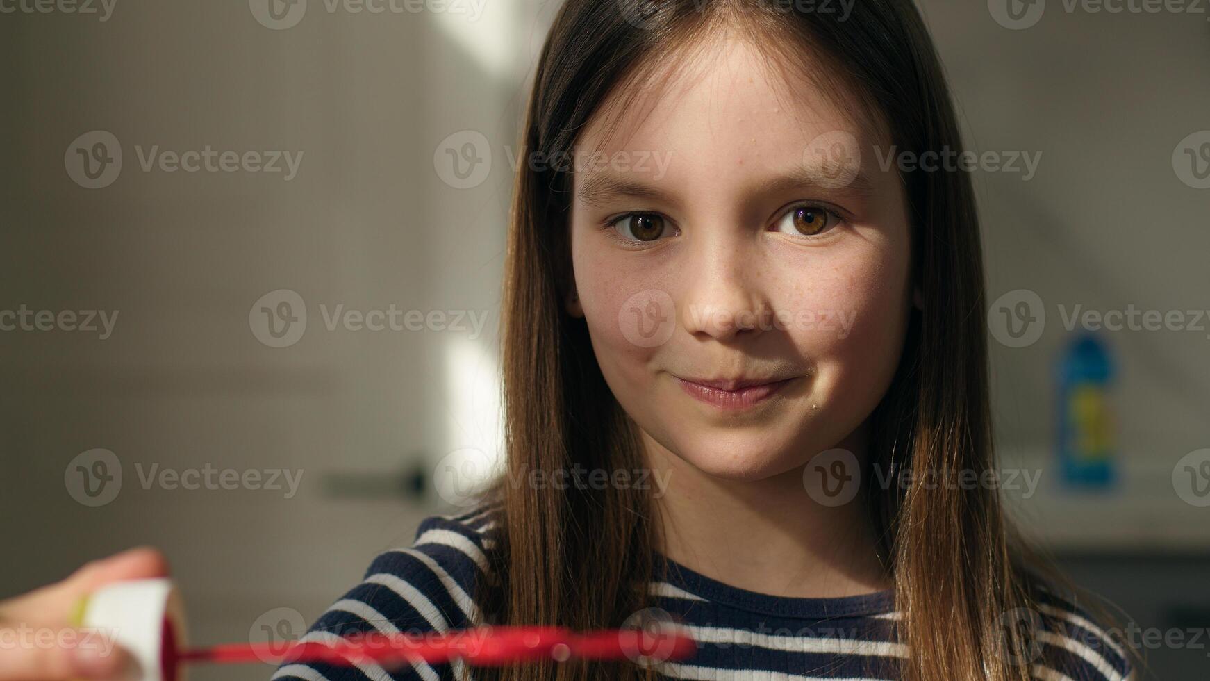 Close up Caucasian little girl holding colorful soap bubbles shine toy entertainment child daughter female kid fun joy smile face enjoying dreamy foam playful delight bright drop reflection pleasure photo