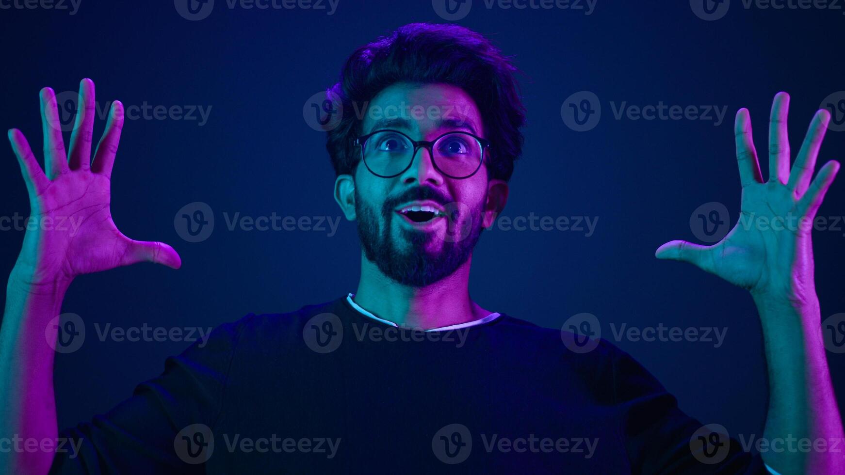 Male portrait neon ultraviolet background Arabian man Indian guy coder hacker showing head mind explosion gesture boom brainstorm idea mental shock information think computer technology sci-fi future photo