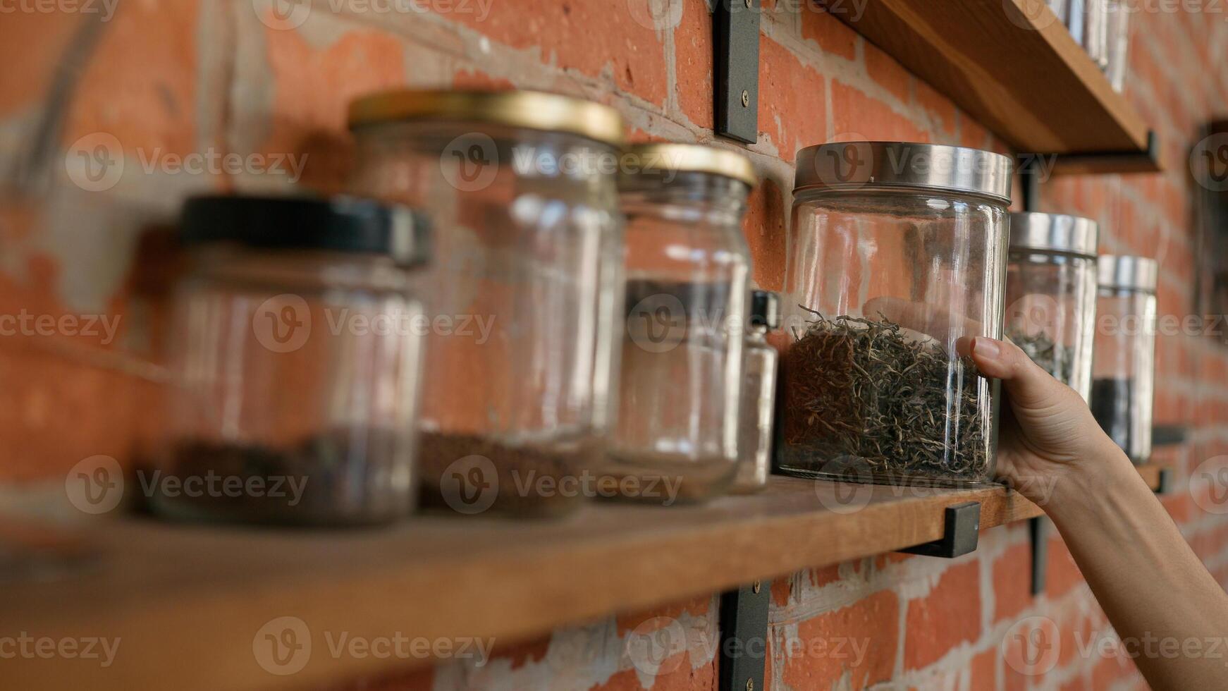 Unrecognizable woman waitress wipe dust on shelf with spices using cleaning duster female girl cafe cleaner cafeteria staff do clean before opening restaurant wiping washing shelves with spice jars photo