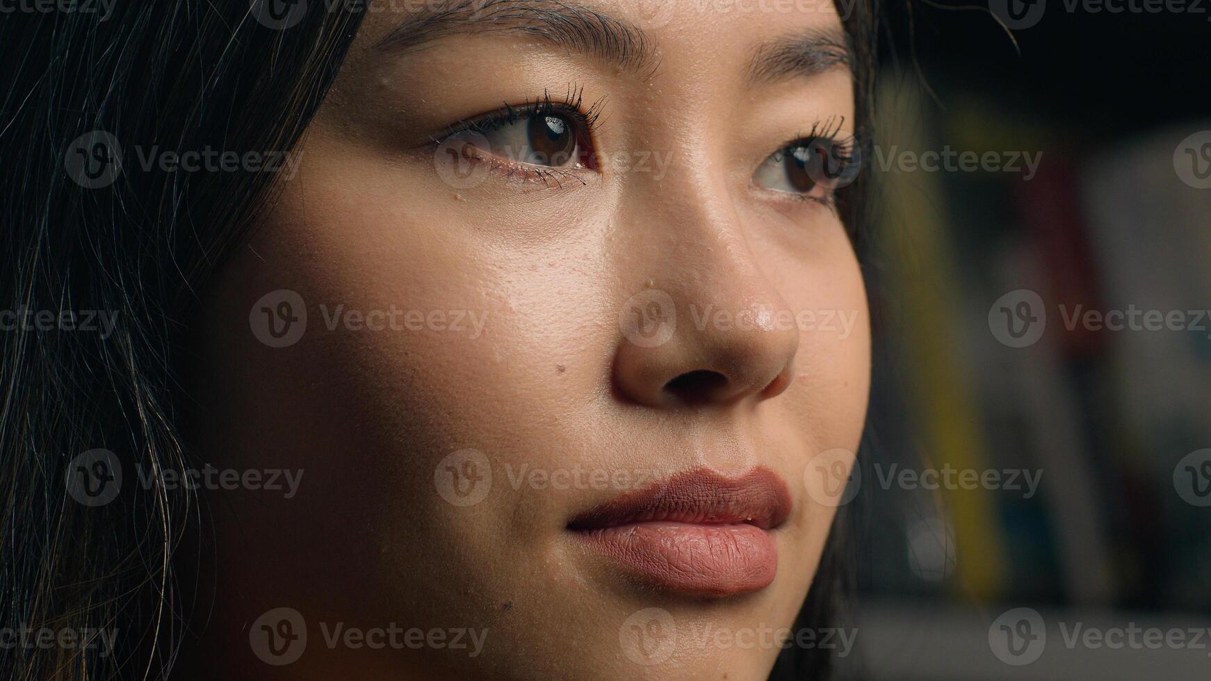 Close-up pensive thoughtful young Asian woman beautiful face chinese ethnic girl student lady looking away in library near bookshelf thinking dream posing indoors think ponder female Korean portrait photo