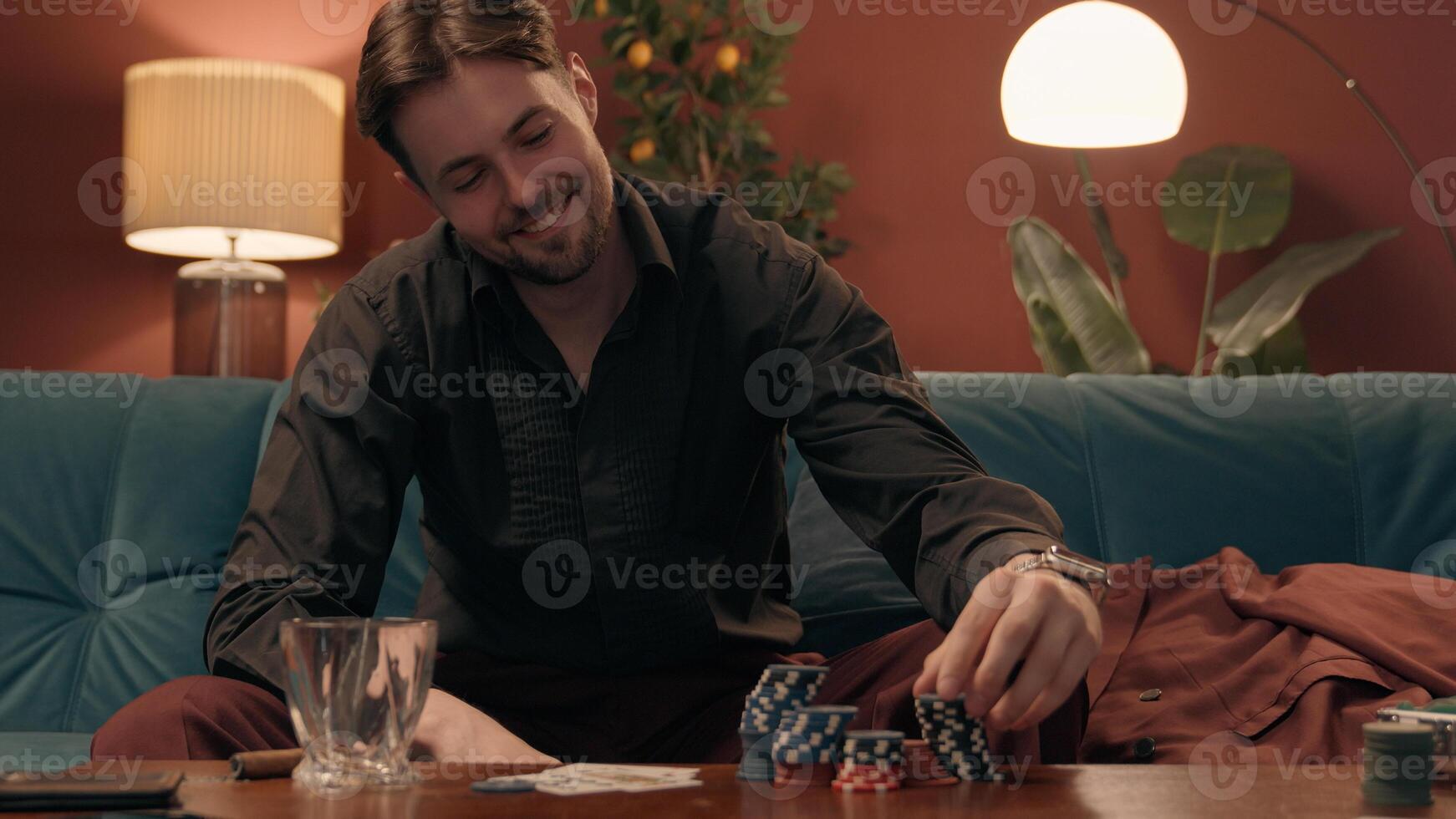 Happy excited smiling Caucasian man male guy winner gamer lucky gambler cheerful player winning jackpot poker success victory many tokens win game gambling casino addiction at home room evening party photo
