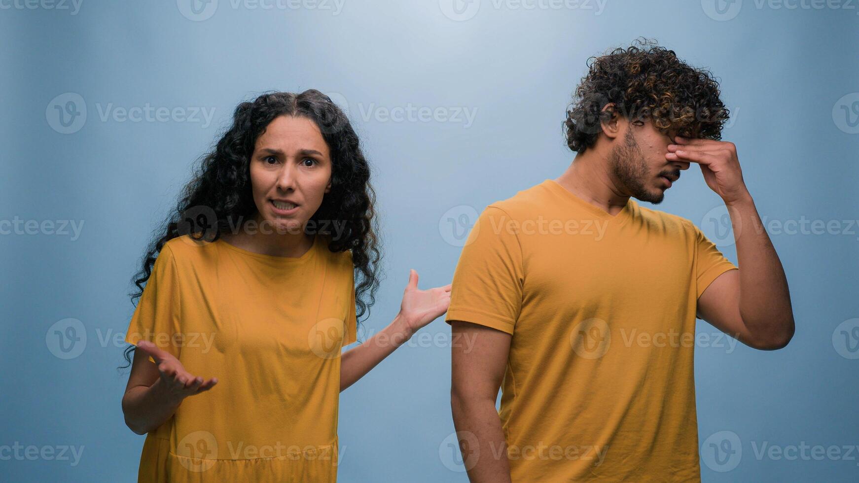 Excited happy shocked wonder amazed surprised Arabian couple winners Indian man woman amazing good news achieve win victory achievement triumph shout screaming yelling winning blue studio background photo