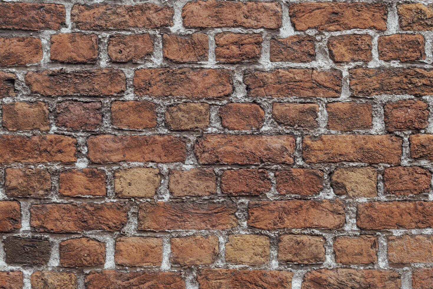 Closeup and detail of an old, weathered wall with reclaimed bricks in irregular patterns photo