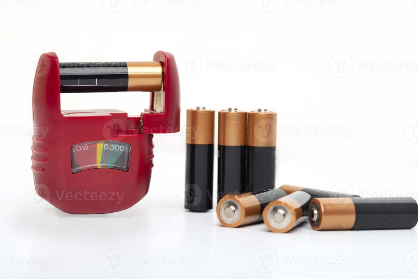 Battery tester, battery level indicator with assortment of dry cells for testing on a white background photo