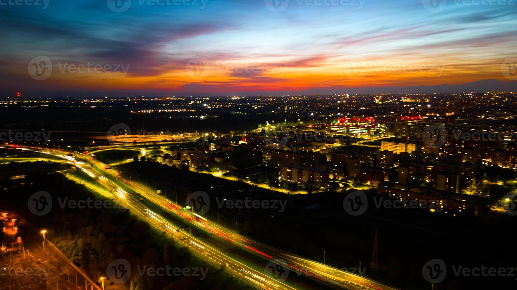 Drone photo huge multi-lane circle roundabout intersection in city traffic highway night city. Public transport commuter pollution business concept. Milan, Italy.