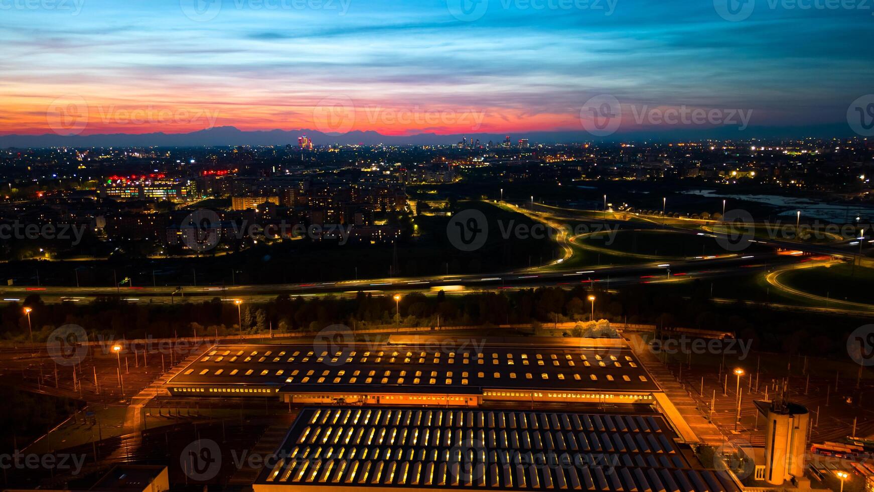 Aerial view huge multi-lane circle roundabout intersection in city traffic highway night city. Public transport commuter pollution business concept. Milan, Italy. photo