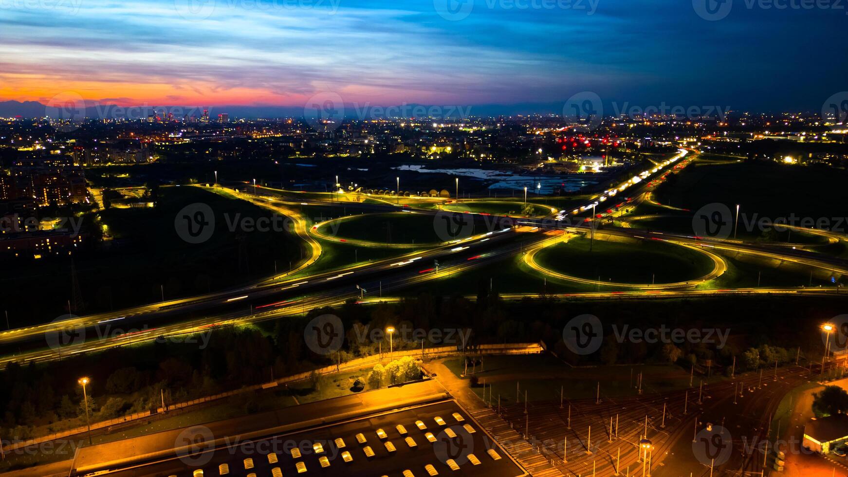 Aerial view huge multi-lane circle roundabout intersection in city traffic highway night city. Public transport commuter pollution business concept. Milan, Italy. photo