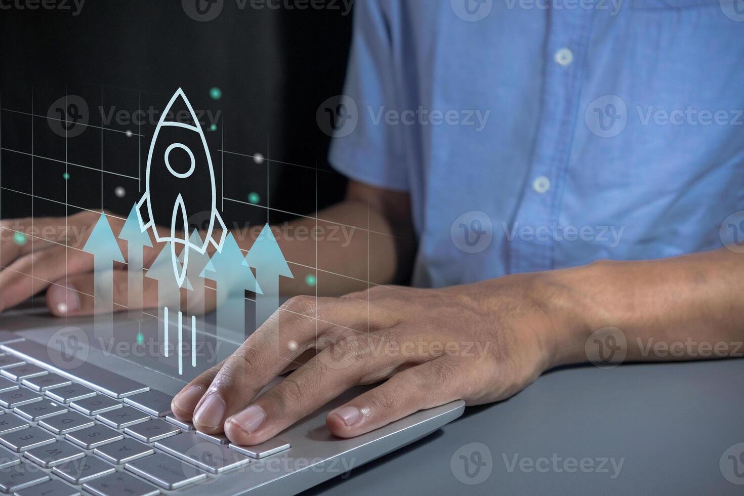 Businessman working on laptop with virtual screen of a rocket and arrow up. Business development, financial plan, startup business concept. photo
