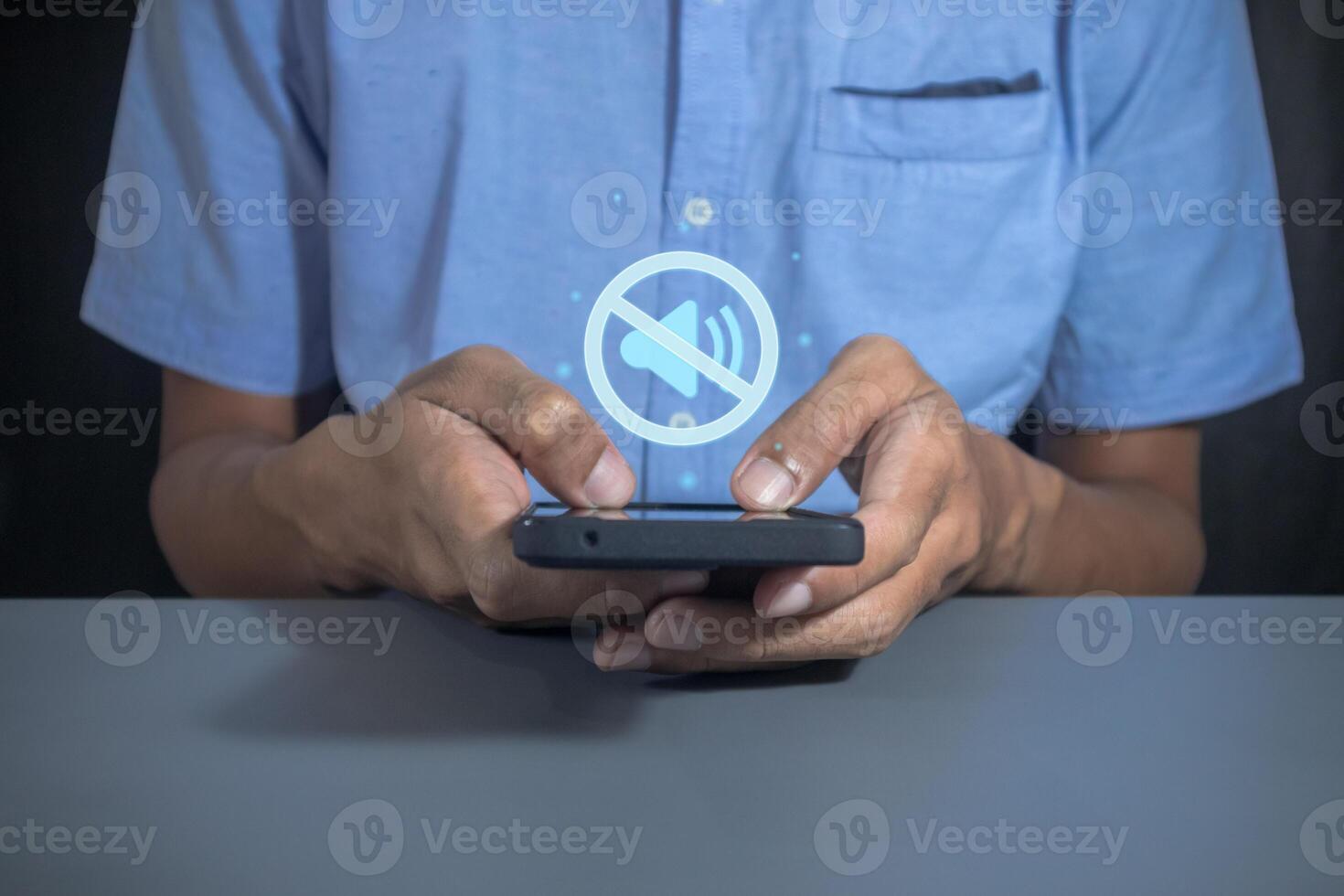 Man holding a mobile phone with mute sound or silent mode symbol photo