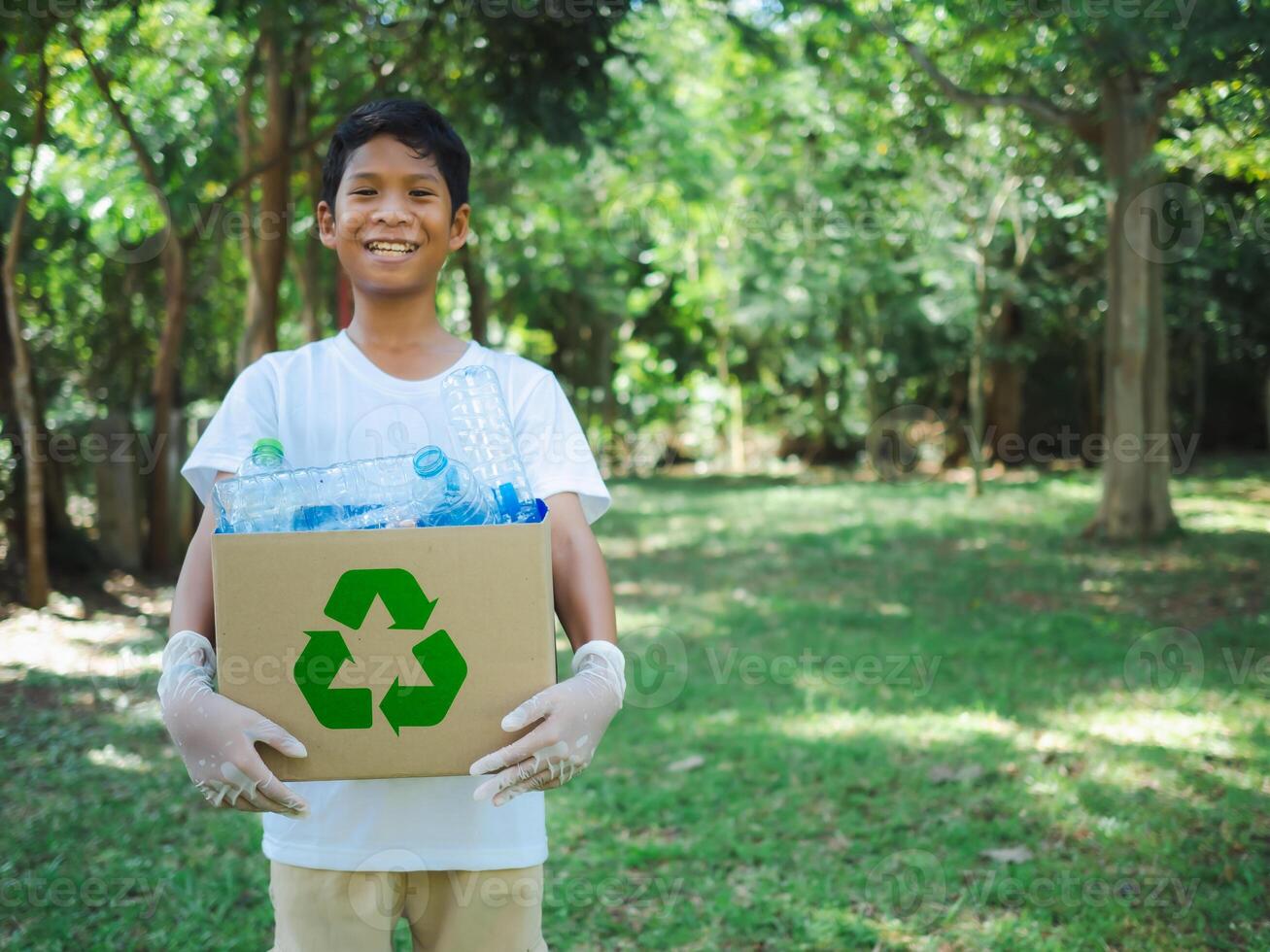 Boy hold cardboard boxes for recycling and holding a recycle bin with plastic bottles in the outdoors, Reduction environmental pollution and recycle concept, Plastic-free, Junk food plastic packaging. photo