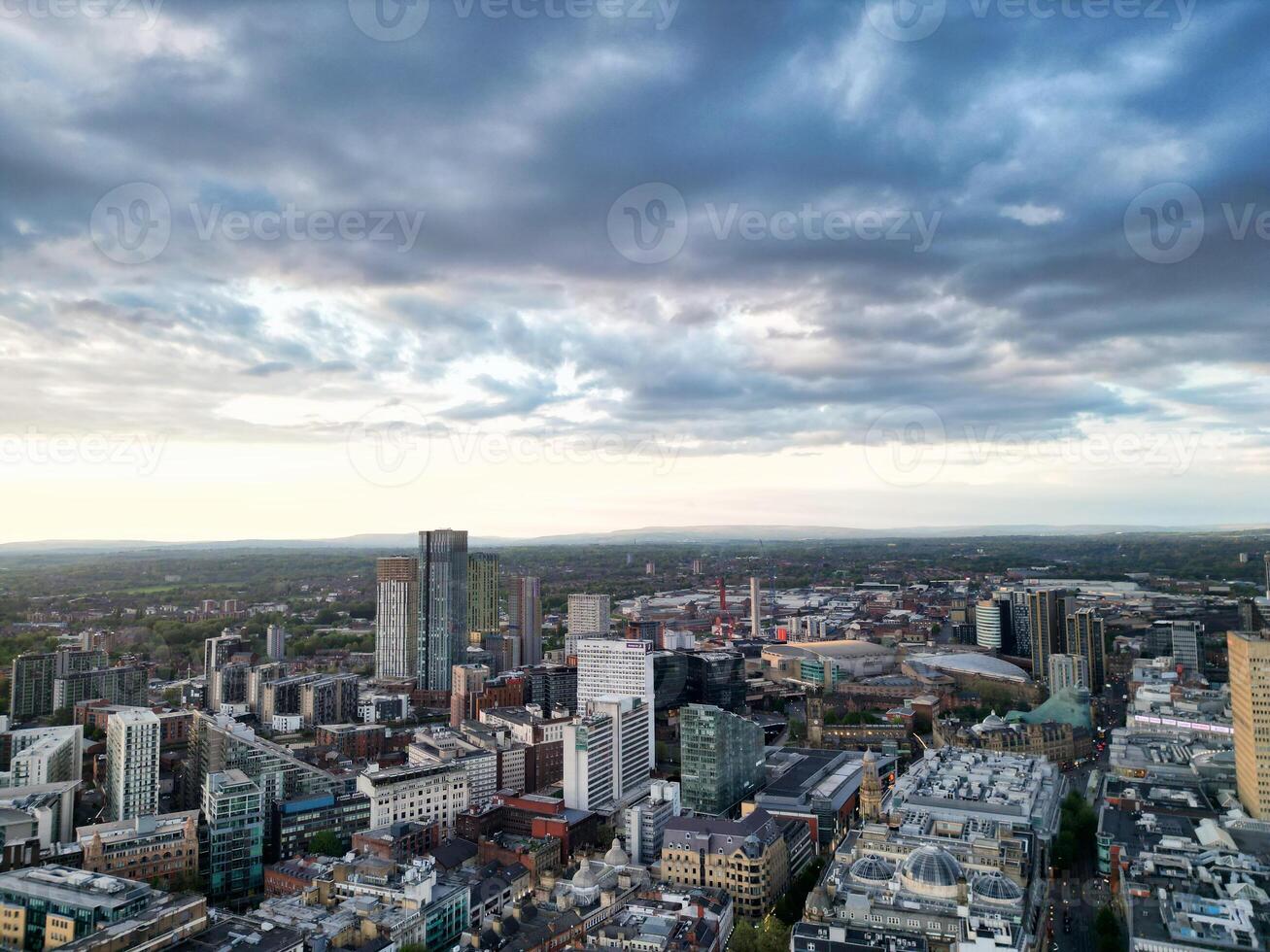 Aerial View of Greater Manchester City Centre and Tall Buildings During Golden Hour of Sunset. England UK. High Angle Footage Was Captured with Drone's Camera During Windy day of May 5th, 2024 photo