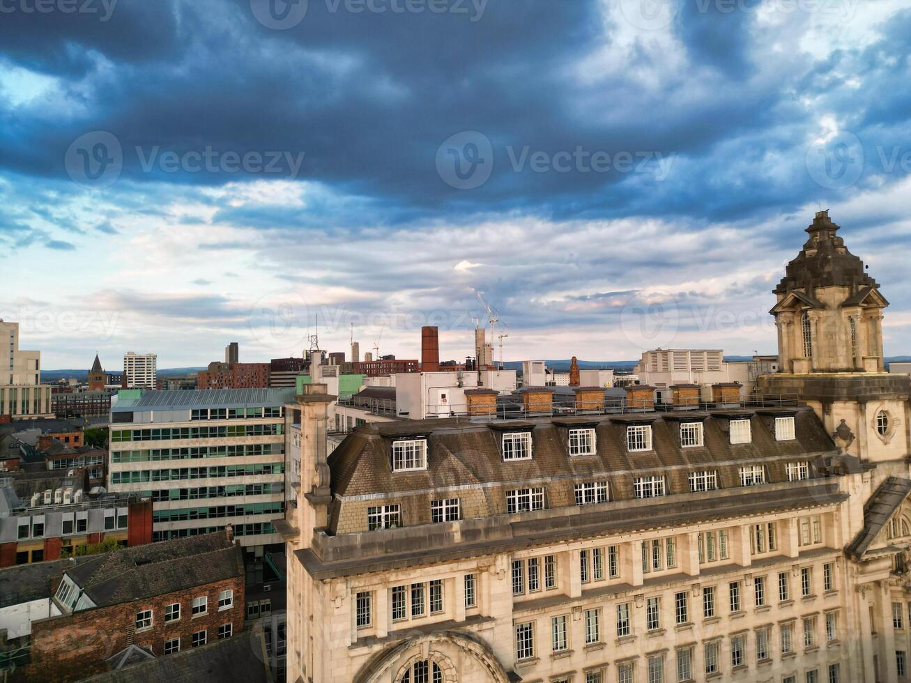 Aerial View of Greater Manchester City Centre and Tall Buildings During Golden Hour of Sunset. England UK. High Angle Footage Was Captured with Drone's Camera During Windy day of May 5th, 2024 photo