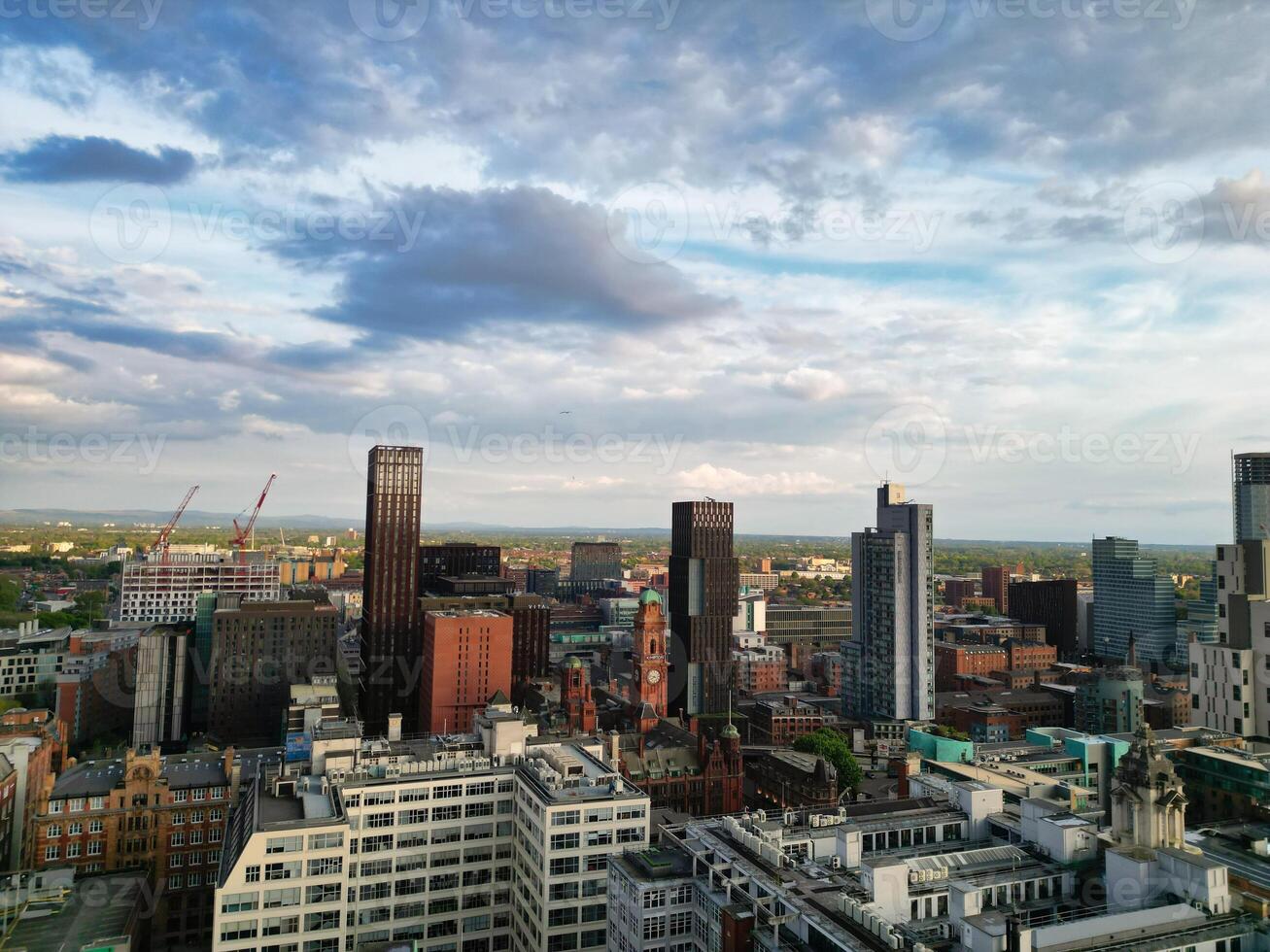 Aerial View of Greater Manchester City Centre and Tall Buildings During Golden Hour of Sunset. England UK. High Angle Footage Was Captured with Drone's Camera During Windy day of May 5th, 2024 photo