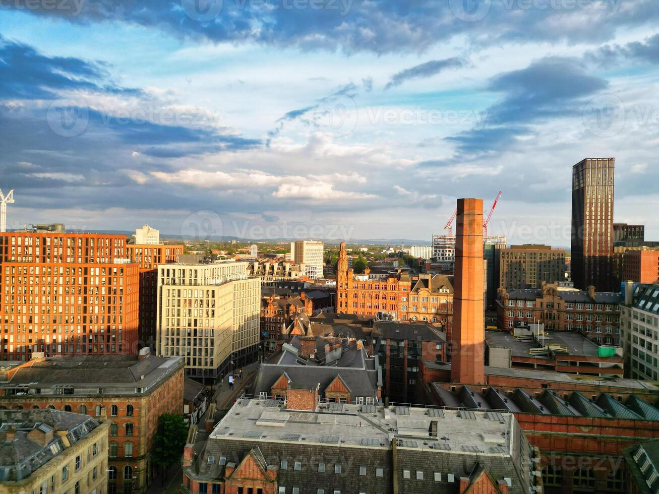 Aerial View of Greater Manchester City Centre and Tall Buildings During Golden Hour of Sunset. England UK. High Angle Footage Was Captured with Drone's Camera During Windy day of May 5th, 2024 photo