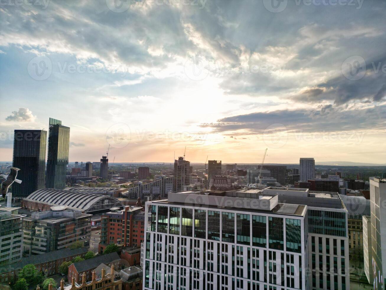 Aerial View of Greater Manchester City Centre and Tall Buildings During Golden Hour of Sunset. England UK. High Angle Footage Was Captured with Drone's Camera During Windy day of May 5th, 2024 photo