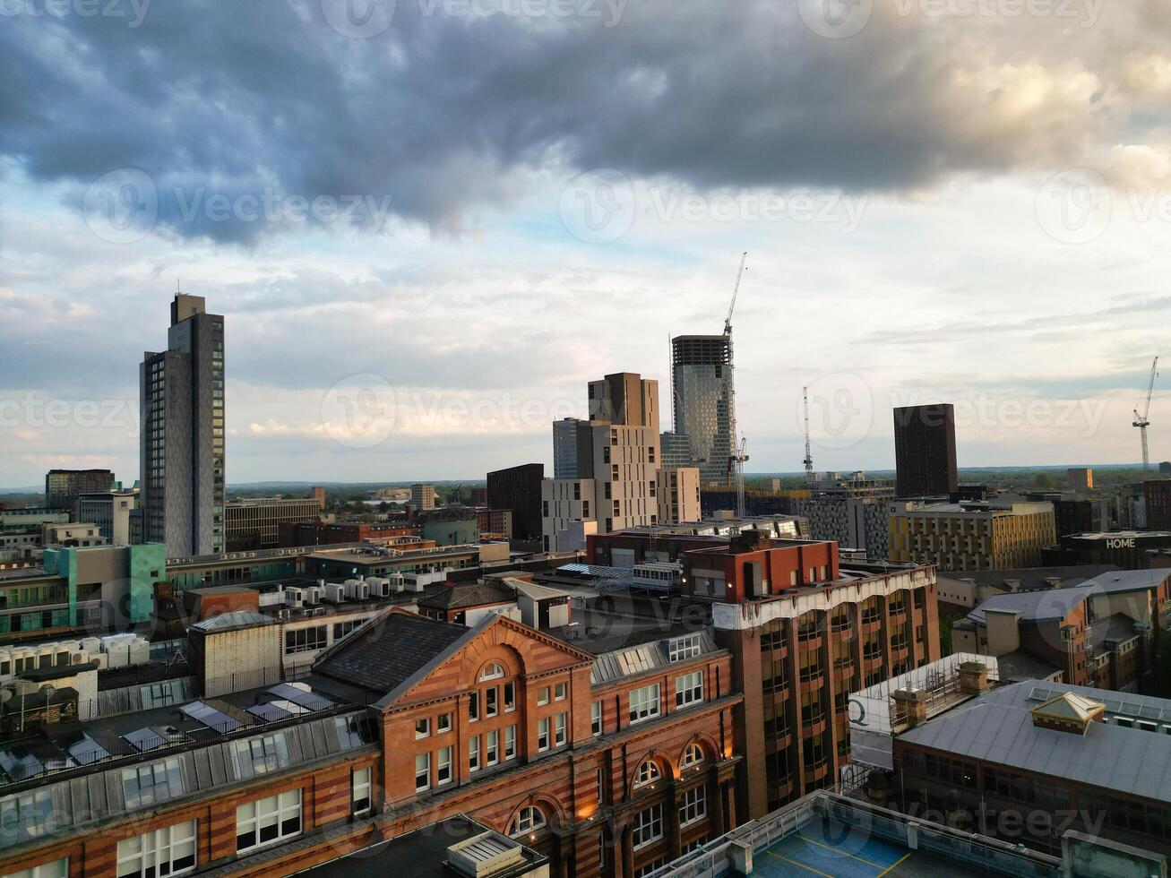 Aerial View of Greater Manchester City Centre and Tall Buildings During Golden Hour of Sunset. England UK. High Angle Footage Was Captured with Drone's Camera During Windy day of May 5th, 2024 photo