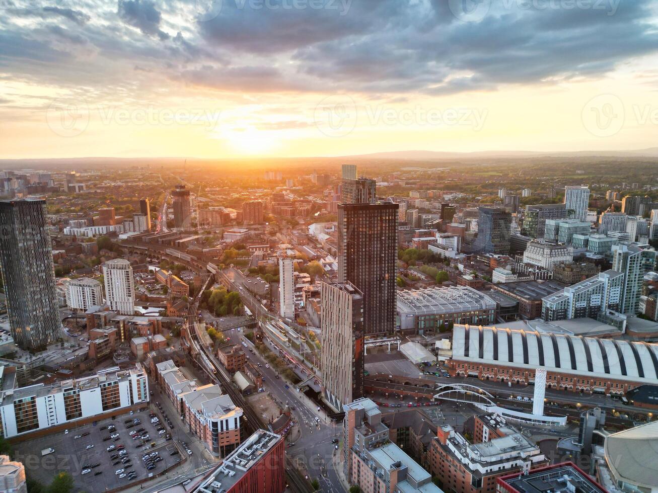 Aerial View of Greater Manchester City Centre and Tall Buildings During Golden Hour of Sunset. England UK. High Angle Footage Was Captured with Drone's Camera During Windy day of May 5th, 2024 photo