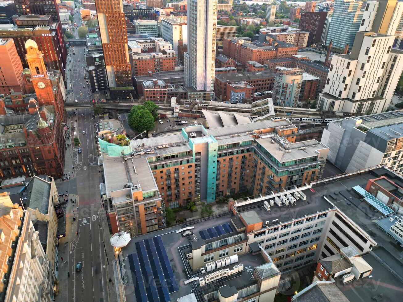 Aerial View of Greater Manchester City Centre and Tall Buildings During Golden Hour of Sunset. England UK. High Angle Footage Was Captured with Drone's Camera During Windy day of May 5th, 2024 photo