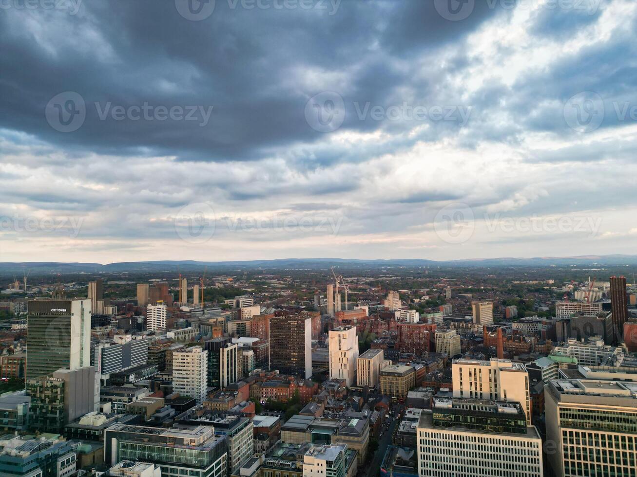 Aerial View of Greater Manchester City Centre and Tall Buildings During Golden Hour of Sunset. England UK. High Angle Footage Was Captured with Drone's Camera During Windy day of May 5th, 2024 photo